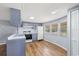 Kitchen featuring laminate floors, white appliances, and sleek blue-gray cabinets and countertops at 9401 Bourbon St, New Port Richey, FL 34654