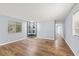 Bright living room featuring laminate floors, a built-in cabinet, and large windows at 9401 Bourbon St, New Port Richey, FL 34654