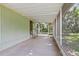 Covered patio featuring concrete flooring, a screened enclosure, and a convenient entrance at 9401 Bourbon St, New Port Richey, FL 34654
