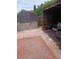 Backyard patio featuring stacked stones, wood fence, and a covered barbeque grill at 9516 Glen Moor Ln, Port Richey, FL 34668