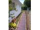 Landscaped backyard featuring a brick pathway, greenery, and fenced area adding charm to the property at 9516 Glen Moor Ln, Port Richey, FL 34668