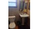 Bathroom featuring a pedestal sink, toilet, and tiled walls, creating a functional space at 9516 Glen Moor Ln, Port Richey, FL 34668