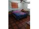 Bedroom with a patterned bedspread, matching tile floor, and a ceiling fan at 9516 Glen Moor Ln, Port Richey, FL 34668