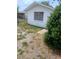 Exterior view showing the side of the white home with a window and landscape at 9516 Glen Moor Ln, Port Richey, FL 34668