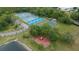 An aerial view of community amenities including tennis courts, a playground, and a serene lake at 10044 Twelve Oaks Ct, Weeki Wachee, FL 34613