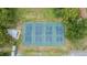 An aerial view of well-maintained tennis courts surrounded by lush greenery, enhancing the community's appeal at 10044 Twelve Oaks Ct, Weeki Wachee, FL 34613