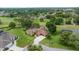 Aerial view of a beautiful house with a manicured lawn, an extra large concrete driveway, mature trees and lush landscaping at 10044 Twelve Oaks Ct, Weeki Wachee, FL 34613