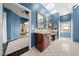 Luxurious bathroom with double vanity, tile floors, blue walls and an open floor plan at 10044 Twelve Oaks Ct, Weeki Wachee, FL 34613