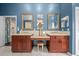 Luxurious bathroom with double vanity, tile floors, blue walls, and a makeup station at 10044 Twelve Oaks Ct, Weeki Wachee, FL 34613