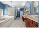 Large modern bathroom with tile floors, soaking tub, dual sinks, and a glass block window at 10044 Twelve Oaks Ct, Weeki Wachee, FL 34613