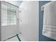 Bright bathroom featuring a shower with glass block window and blue and white tile at 10044 Twelve Oaks Ct, Weeki Wachee, FL 34613