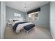 Bedroom with a white bed, blue accents, and a large window letting in natural light at 10044 Twelve Oaks Ct, Weeki Wachee, FL 34613