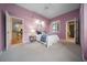Lavender primary bedroom with carpet, a bed, and ensuite bath and access to the kitchen at 10044 Twelve Oaks Ct, Weeki Wachee, FL 34613