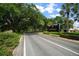 Beautiful GlenLakes community entrance featuring lush landscaping, mature trees, and an elegant sign at 10044 Twelve Oaks Ct, Weeki Wachee, FL 34613