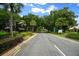 A tranquil entrance to the GlenLakes community featuring lush landscaping and mature trees lining the roadway at 10044 Twelve Oaks Ct, Weeki Wachee, FL 34613