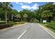 A tranquil entrance to the GlenLakes community featuring lush landscaping and mature trees lining the roadway at 10044 Twelve Oaks Ct, Weeki Wachee, FL 34613