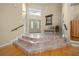 View of the home's foyer showcasing a marble floor entryway, stairs, and a decorative mirror and bench at 10044 Twelve Oaks Ct, Weeki Wachee, FL 34613