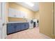 Functional laundry room with modern washer, dryer, and cabinet and countertop space at 10044 Twelve Oaks Ct, Weeki Wachee, FL 34613