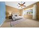 Comfortable main bedroom featuring a ceiling fan, tan walls, and an area rug at 10044 Twelve Oaks Ct, Weeki Wachee, FL 34613
