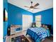 Bright bedroom features a ceiling fan, ample closet space, desk, and laminate floors at 10120 Ives Loop, Hudson, FL 34667