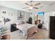 This bedroom is equipped with a ceiling fan, a TV, an attached bath, and sleek laminate floors at 10120 Ives Loop, Hudson, FL 34667