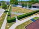 Aerial view of community green space surrounded by green bushes and a white fence near the community playground at 10120 Ives Loop, Hudson, FL 34667