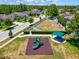 Aerial view of a community playground featuring a play structure, picnic pavilion, and fenced green space at 10120 Ives Loop, Hudson, FL 34667