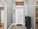 Bright entryway with coat rack, shoe storage, and small transom window above the door at 10120 Ives Loop, Hudson, FL 34667