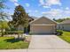 Charming single-story home with a two-car garage, landscaped front yard, and mature magnolia tree at 10120 Ives Loop, Hudson, FL 34667