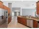 Bright kitchen featuring stainless steel appliances, wood cabinets, granite countertops, and an open floor plan at 10120 Ives Loop, Hudson, FL 34667