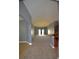 Open-concept living space with plush carpeting, vaulted ceilings, and an abundance of natural light at 10120 Ives Loop, Hudson, FL 34667