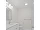A well-lit bathroom featuring a large mirror, modern vanity, and white tile is the perfect oasis at 1024 Spindle Palm Way, Apollo Beach, FL 33572