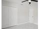 This well-lit bedroom features neutral paint, white marble floors, a ceiling fan, and a double door closet at 1024 Spindle Palm Way, Apollo Beach, FL 33572