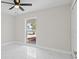 Bright bedroom with white marble floors, closet and a window at 1024 Spindle Palm Way, Apollo Beach, FL 33572