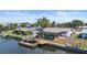 Waterfront home featuring a backyard pool, dock, seawall and boat lift on a sunny day at 1024 Spindle Palm Way, Apollo Beach, FL 33572