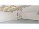 Spacious, unfinished two-car garage with a smooth floor and overhead ceiling support at 1024 Spindle Palm Way, Apollo Beach, FL 33572