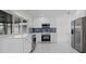 Modern kitchen featuring stainless steel appliances, white cabinetry, and blue subway tile backsplash at 1024 Spindle Palm Way, Apollo Beach, FL 33572