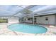 A pristine pool is surrounded by a screened enclosure and light brick pavers, offering privacy and outdoor enjoyment at 1024 Spindle Palm Way, Apollo Beach, FL 33572
