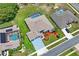 Aerial view of home with a screened pool, manicured lawn, and colorful landscaping at 10250 Locker Dr, Spring Hill, FL 34608