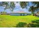 Backyard home view of the house featuring an enclosed pool area and ample green space at 10250 Locker Dr, Spring Hill, FL 34608