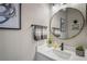 Modern bathroom features a round mirror, gray towels, and a white vanity at 10250 Locker Dr, Spring Hill, FL 34608