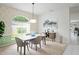 Bright dining room with a floral accent wall, modern light fixture, and a large window offering plenty of natural light at 10250 Locker Dr, Spring Hill, FL 34608