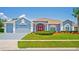 Charming single-story home with a well-manicured lawn, red front door, and attached two-car garage at 10250 Locker Dr, Spring Hill, FL 34608
