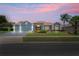 Charming single-story home with a well-manicured lawn, red front door, and attached two-car garage at dusk at 10250 Locker Dr, Spring Hill, FL 34608