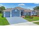 Charming blue home boasts a well-manicured lawn and a convenient two-car garage at 10250 Locker Dr, Spring Hill, FL 34608