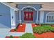Charming home featuring a bright red double door and well-manicured front yard at 10250 Locker Dr, Spring Hill, FL 34608