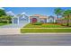 Charming single-story home with a well-manicured lawn, red front door, and attached two-car garage at 10250 Locker Dr, Spring Hill, FL 34608
