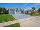 Charming home featuring a three-car garage, well-manicured lawn, and vibrant landscaping for great curb appeal at 10250 Locker Dr, Spring Hill, FL 34608