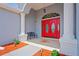 Inviting front porch featuring a bright red double door, elegant columns, and a cozy bench at 10250 Locker Dr, Spring Hill, FL 34608