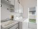Laundry room features a utility sink, white cabinets, and modern appliances at 10250 Locker Dr, Spring Hill, FL 34608